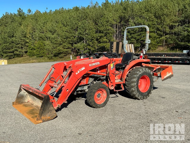 Actual IronPlanet photo of the orange Kubota with front loader, bucket and rear box blade